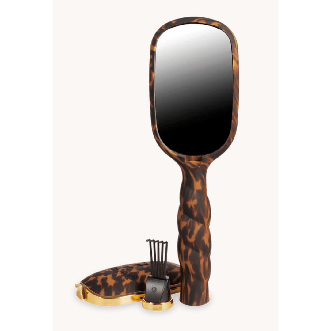 Leopard print hairbrush with mirror and case on a white background