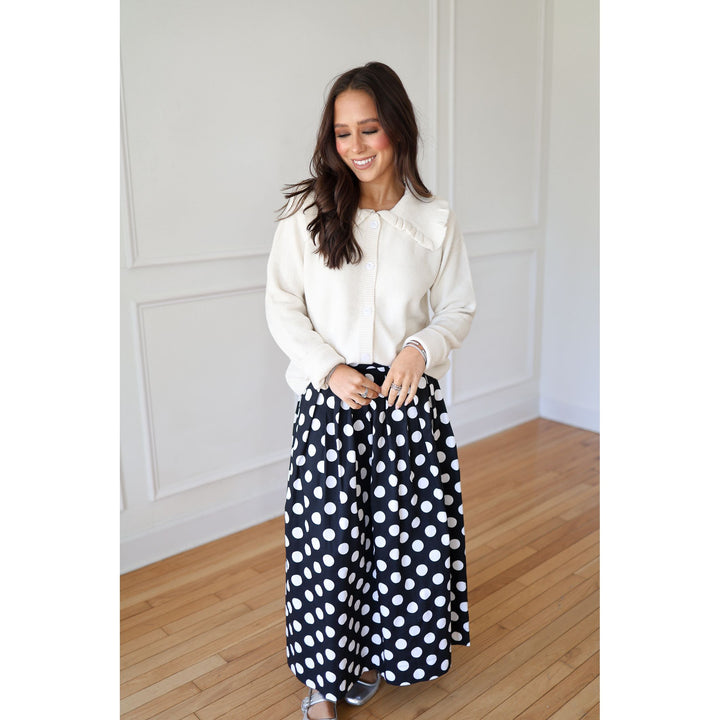 woman wearing white polka dot skirt and white cardigan