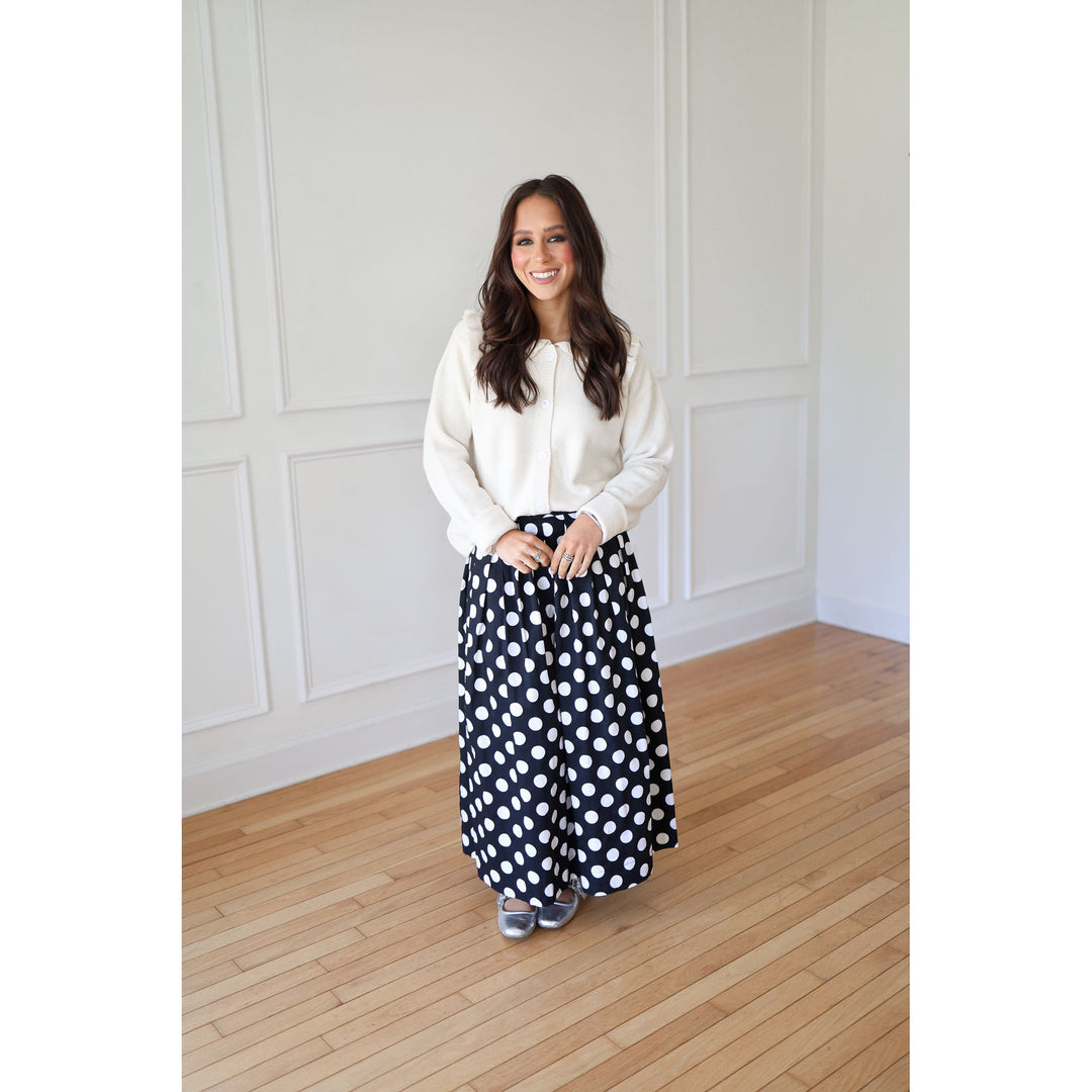 Woman wearing a white blouse and polka dot pants 