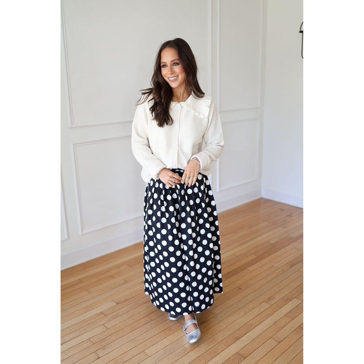 Woman wearing a white blouse and black polka dot skirt 