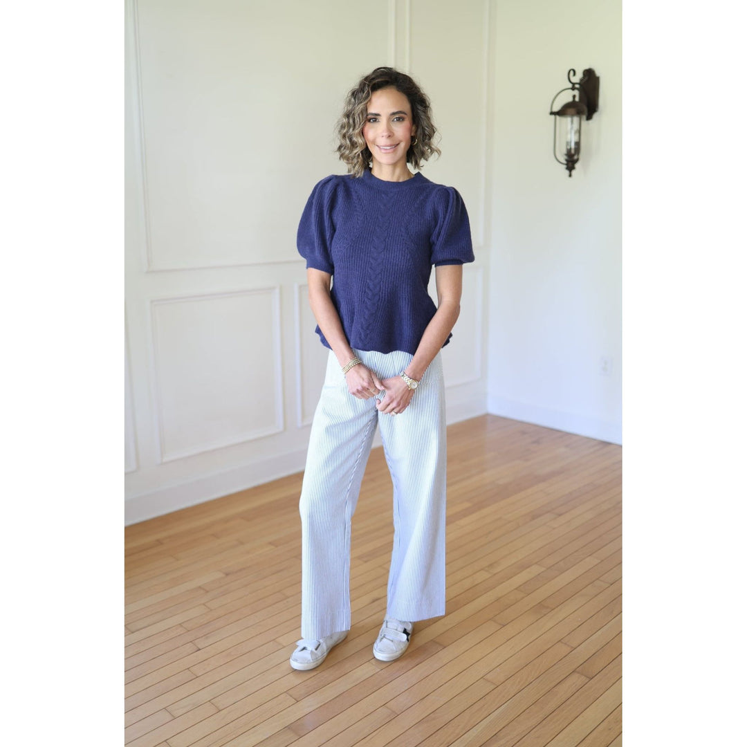 Woman wearing a blue top and white pants 