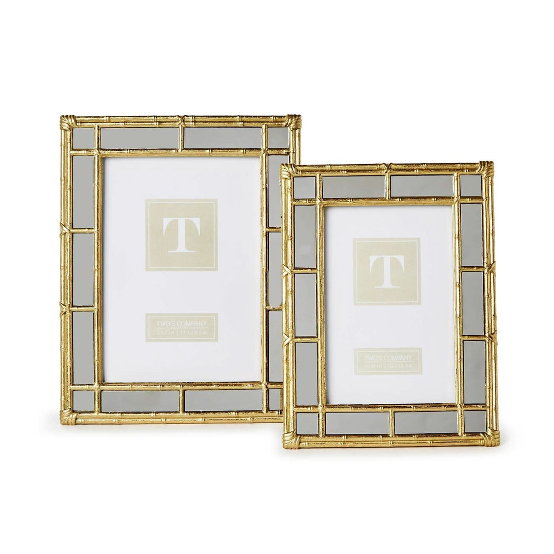 Two gold picture frames with glass panels on a white background