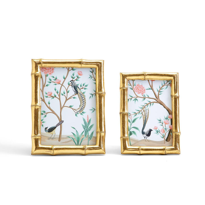 Two gold picture frames with floral and bird designs on a white background