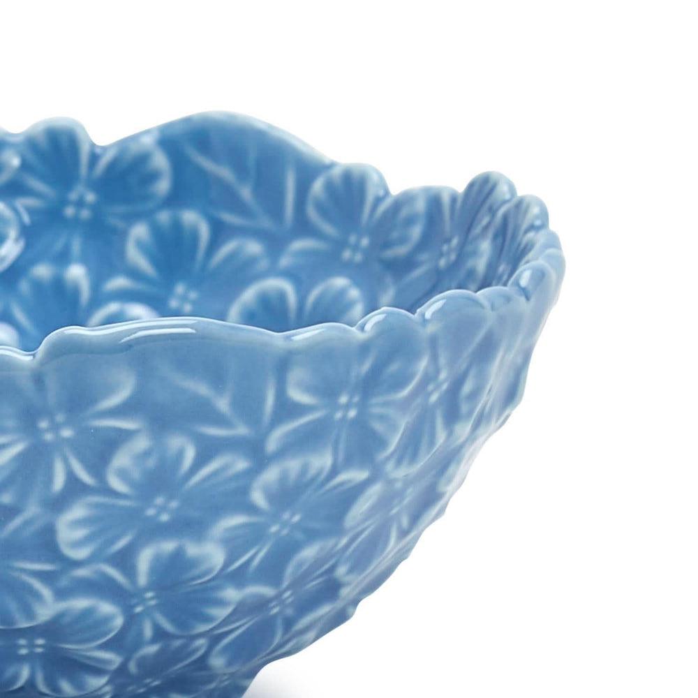 Blue ceramic bowl with floral pattern on a white background