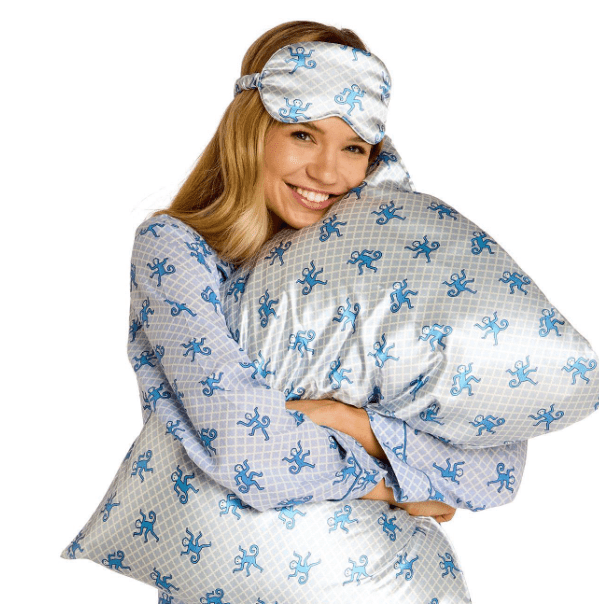 Woman wearing a matching robe and sleep mask with blue monkey patterns on a white background