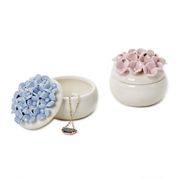 Two ceramic jewelry holders with floral designs on a white background