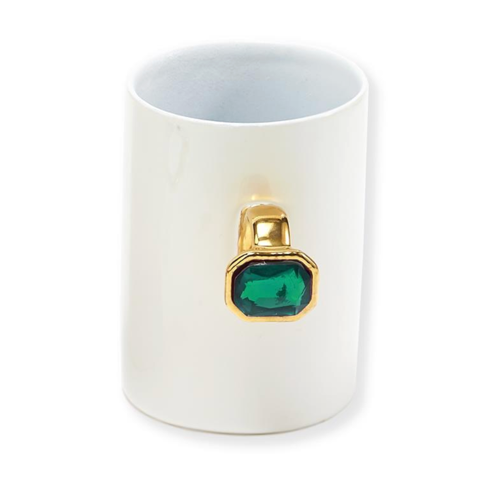 White mug with a gold ring featuring a green gemstone 