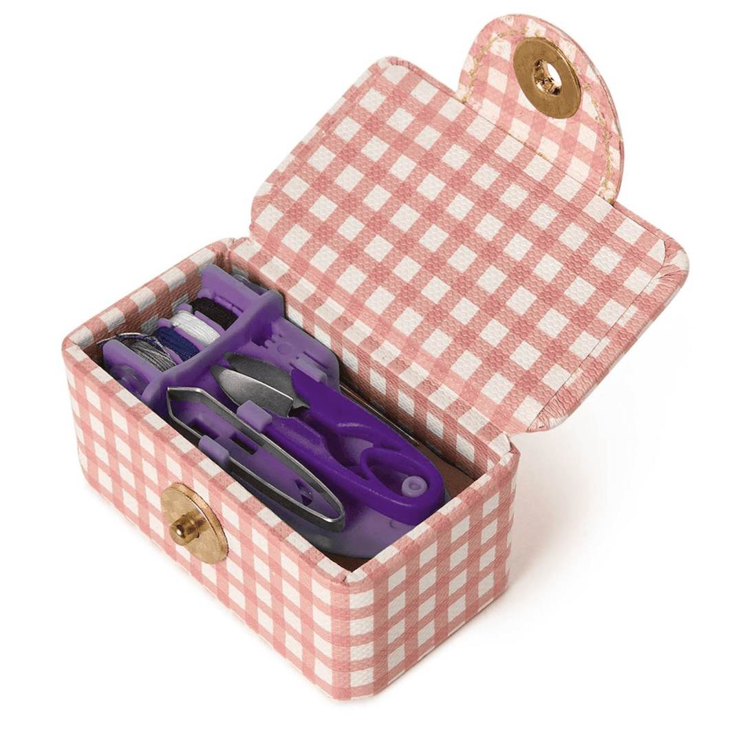 Pink gingham-patterned jewelry box with purple scissors inside on a white background