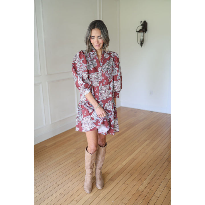 Woman wearing a red patterned dress and beige knee-high boots 