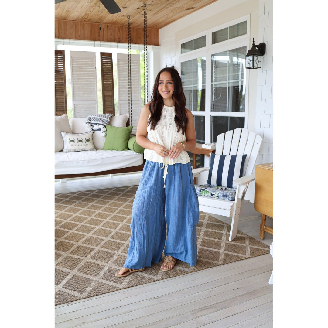 Woman standing on a porch with a white house in the background