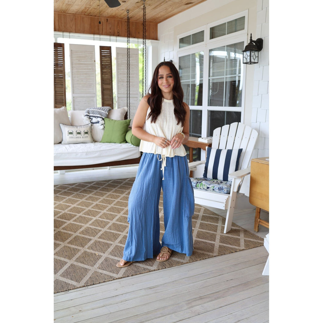 Woman standing on a porch with a white house in the background